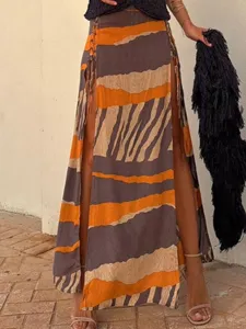 Λεπτομέρεια γυναικείας boho μακριάς φούστας με αφηρημένες ρίγες, ψηλό σκίσιμο και κορδόνια.