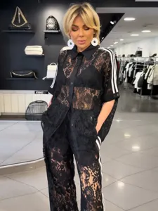 Black lace matching set featuring a short sleeve shirt and trousers with side stripes.