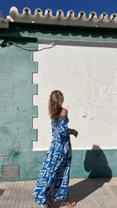 Detalle de vestido largo maxi estampado azul y blanco con hombros descubiertos, estilo bohemio.