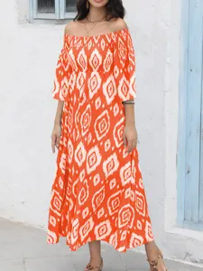 Vista detallada del vestido largo naranja con hombros descubiertos y diseño geométrico ikat.