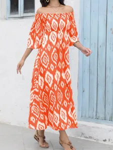 Detalle de vestido largo naranja con hombros descubiertos, estampado abstracto vibrante, verano.