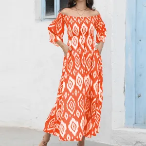 Vista detallada del vestido largo naranja con estampado geométrico y hombros descubiertos.