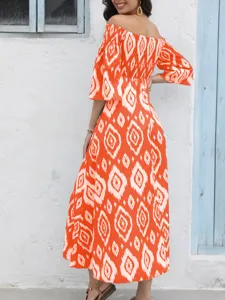 Detalle del vestido largo boho con hombros descubiertos y estampado geométrico de verano.
