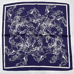 Close-up of luxury dark blue silk scarf with white horse pattern and elegant French border.