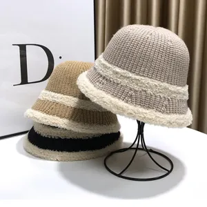 Detailed view of winter plush-trimmed knitted bucket hat, cozy warm headwear on display stand.