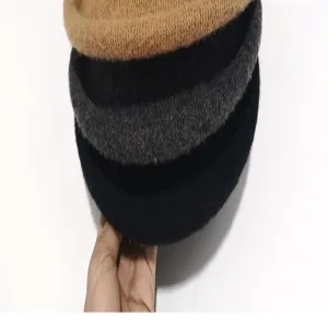 Close-up detail of stacked winter wool blend rolled brim basin hats in multiple classic colors.