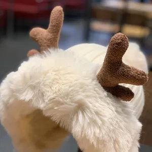 Gros plan détaillé du bonnet en peluche avec bois de renne d'hiver, bord en fausse fourrure.