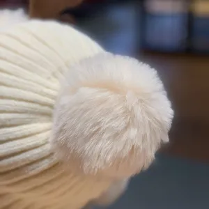 Vue rapprochée d'un bonnet en tricot chaud et mignon pour femme avec un pompon duveteux.