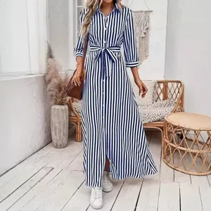 Vestido camisero rayado en azul y blanco con manga larga, cinturón y abertura frontal.