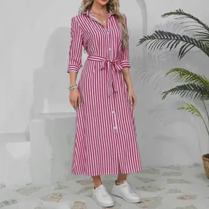 Vista detallada del vestido camisero de rayas rosa y blanco con cinturón y cuello estilo vacacional.