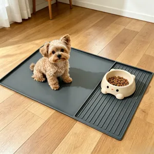 Detail shot of grey silicone pet feeding mat with raised edges and bowl area on wood floor.