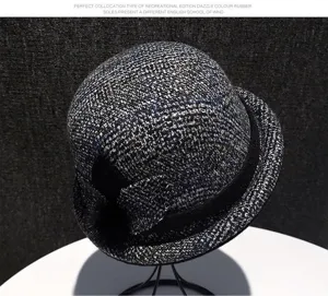 Close-up detail of the vintage grey tweed bucket hat with black ribbon and bow accent.
