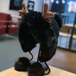Bonnet aviateur en peluche noire avec adorables bois de renne marron et pompons, détail d'hiver