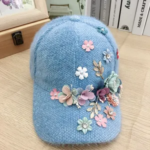 Primo piano del berretto da baseball in peluche blu con strass scintillanti e fiori.