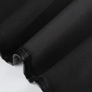 Close-up of black PU leather fabric detail, showing dark style corset fine stitch.
