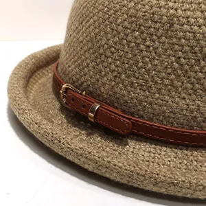 Stylish women's woven fedora hat with brown leather strap and gold buckle detail.