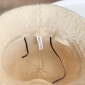 Detailed view of the cozy beige knit bucket hat interior, showing quality texture and stitching.