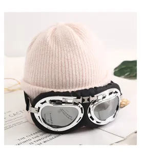 Primer plano detallado del gorro de punto cálido con gafas de piloto elegantes en rosa.