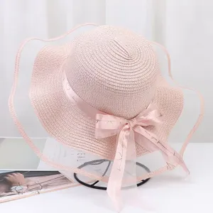 Pink straw sun hat detail featuring a wide mesh veil and elegant ribbon bow with sweet love text.