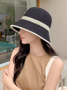 Stylish black and white straw bucket hat for women, wide brim breathable summer sun hat.