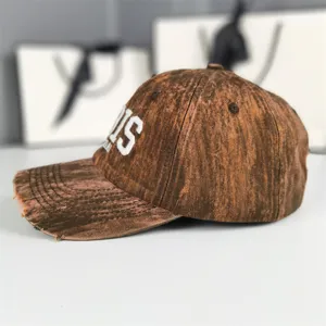 Casquette de baseball marron effet vieilli vintage avec broderie latérale blanche streetwear.