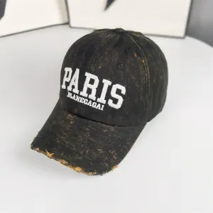 Casquette de baseball noire effet usé avec broderie blanche, visière courbée et couronne souple.