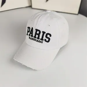 Vue détaillée de la casquette de baseball blanche usée, broderie avant et visière courbée.