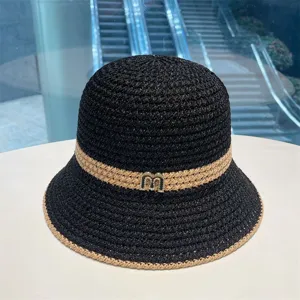 Stylish black woven bucket hat for women, featuring a chic metallic M decor and sun protection.