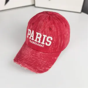 Vue détaillée de la casquette de baseball rouge vintage effet usé avec broderie.