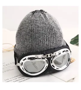 Detalle de gorro de punto de invierno cálido con elegantes gafas de estilo piloto