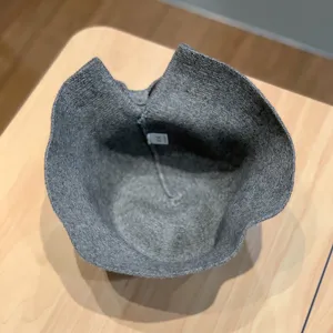 Grey knitted bucket hat detail view, showing the warm wool material and inner structure.