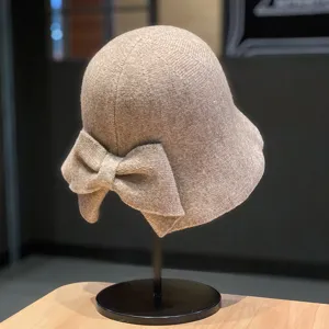 Detail view of knitted winter bucket hat with bow detail, warm wool material, stylish design.