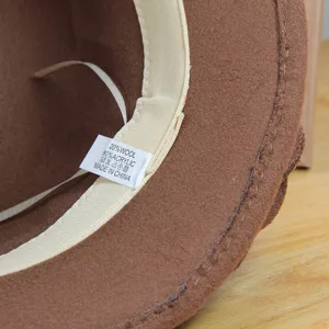 Close up of the inner lining and composition wash tag of a brown vintage wool blend hat detail.
