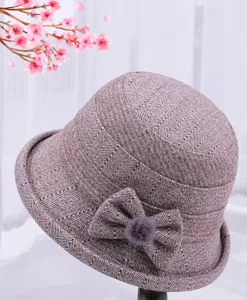 Detailed view of the cozy wool blend winter basin hat with elegant bow and fluffy pom-pom accent.