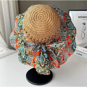Details du chapeau de paille boheme ethnic a large bord avec impression et noeud papillon.