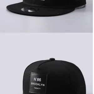 Gorra snapback negra vista de detalle con parche de cuero elegante y texto Brooklyn.