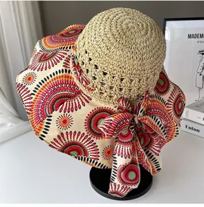 Détail du chapeau de paille à large bord avec motif ethnique coloré et ruban nœud.