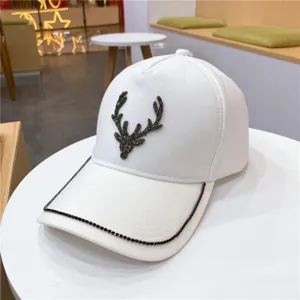 Casquette de baseball blanche avec bois de cerf en strass étincelants et bord de visière.