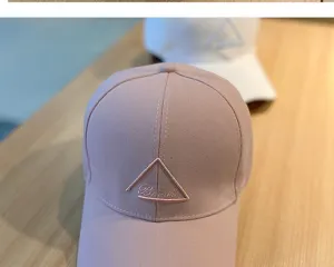 Detail view of a stylish pink baseball cap featuring a unique embroidered triangle design.