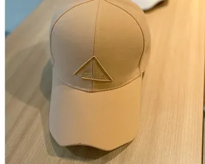 Beige embroidered baseball cap with a classic curved brim and stylish triangle logo design.