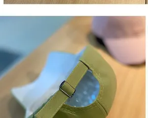 Green baseball cap detail shot showing the back adjustable strap and metal buckle clearly.