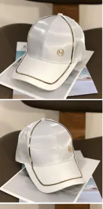 Detailansicht der stilvollen weißen Baseballcap mit goldenen Paspeln und Frontlogo.