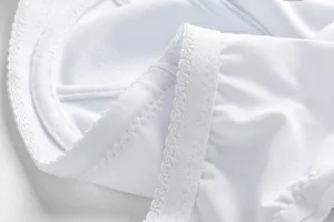 Close-up detail of white seamless bra fabric, showing soft texture and fine stitching.