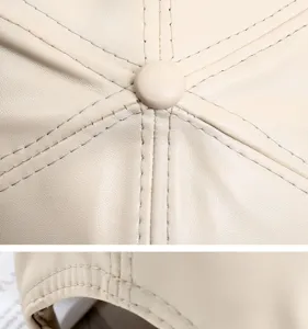 Primo piano dettagliato di un berretto da baseball in pelle beige con cuciture e bottone.