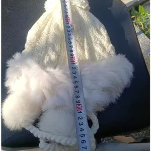 Detailed view of white rabbit fur trapper hat showing size and plush texture craftsmanship.