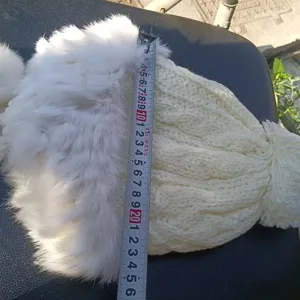 White plush fluffy warm trapper hat with knit cable pattern and fur pompom detail.