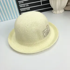 Nahaufnahme Detail des beige gestrickten Eimerhuts mit feiner Textur und seitlichem Label.