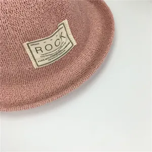 Rosa Strick-Bucket-Hat Detail, texturiertes gewebtes Material mit stylischem Label-Aufnäher.