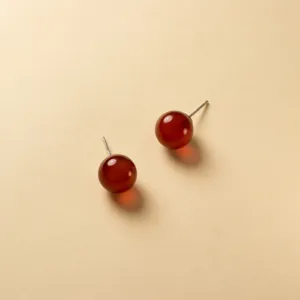 Nahaufnahme Detailaufnahme von roten Achat runden Kugel Ohrringen mit Sterlingsilber Stiften.