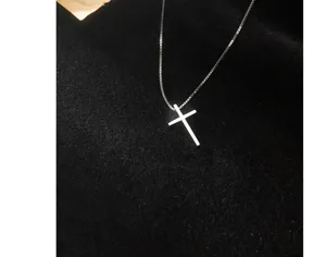 Nahaufnahme des minimalistischen silbernen Kreuz-Anhaenger-Halskettendetails im Detail.